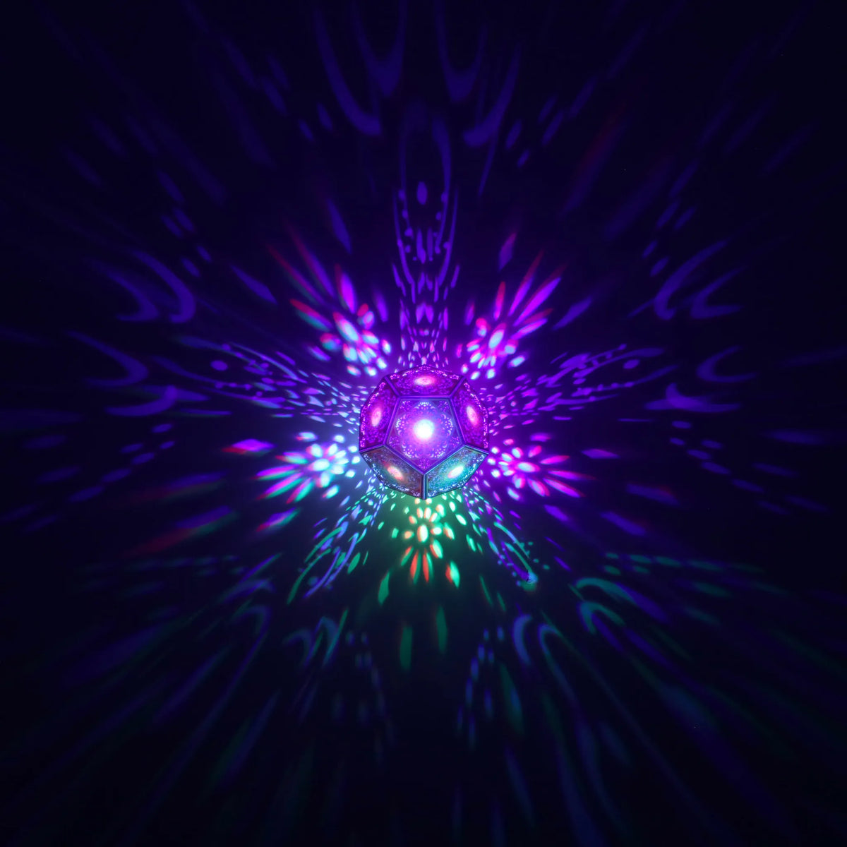 MikhaLuma Logos dodecahedron lantern in Shadow Caster style, geometric pattern projected across a wall