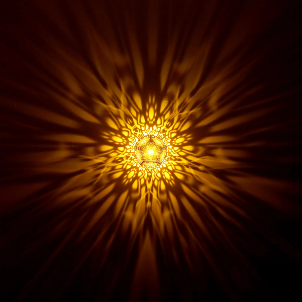 MikhaLuma Telos dodecahedron lantern in Amber style, warm amber light washing a wall