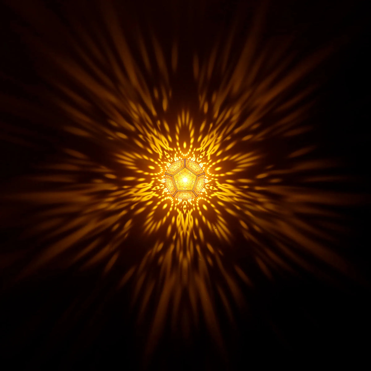 MikhaLuma Aletheia dodecahedron lantern in Amber style, warm amber light washing a wall