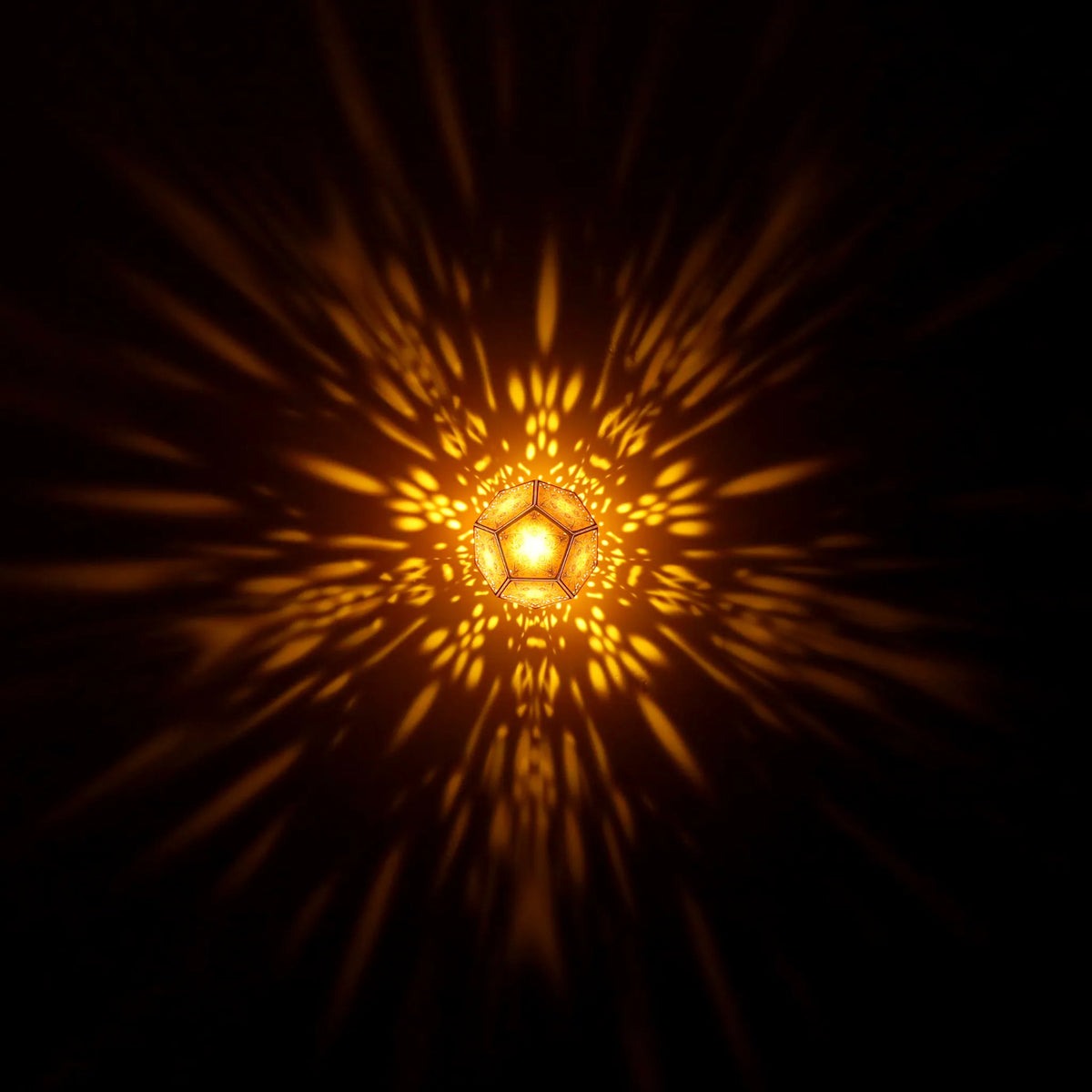 MikhaLuma Phronesis dodecahedron lantern in Amber style, warm amber light washing a wall