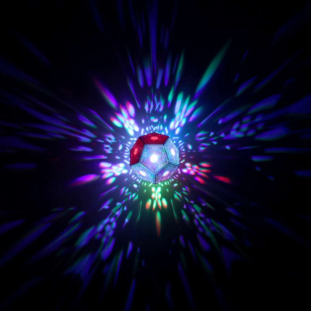 MikhaLuma Phronesis dodecahedron lantern in Shadow Caster style, geometric pattern projected across a wall
