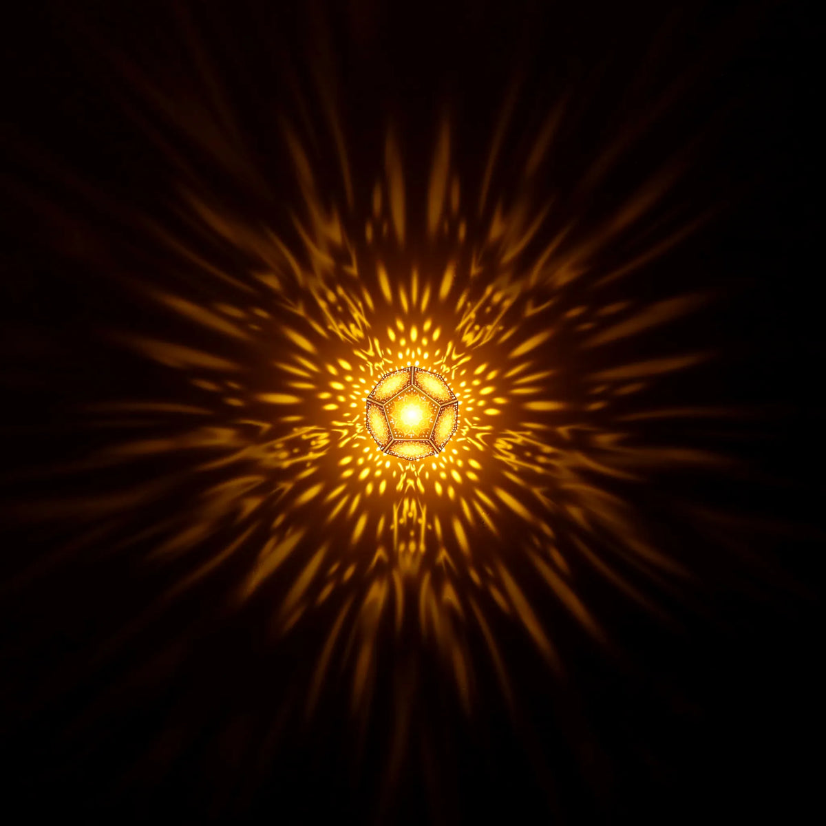 MikhaLuma Oneiros dodecahedron lantern in Amber style, warm amber light washing a wall