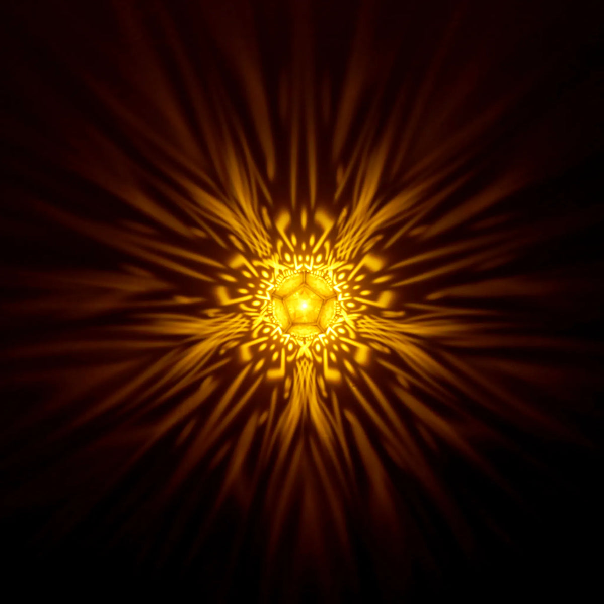MikhaLuma Metanoia dodecahedron lantern in Amber style, warm amber light washing a wall